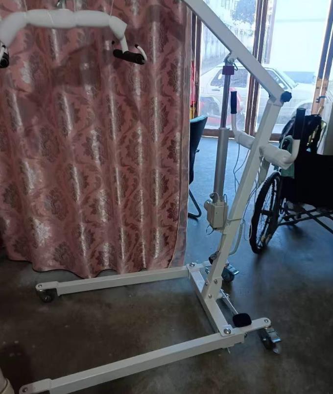 Caregiver using Patient Lift Systems to safely move patient from bed to wheelchair